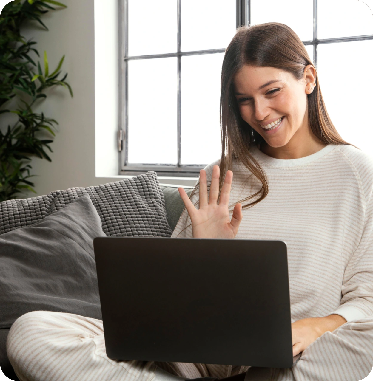 Mujer sonriendo y saludando en video llamada